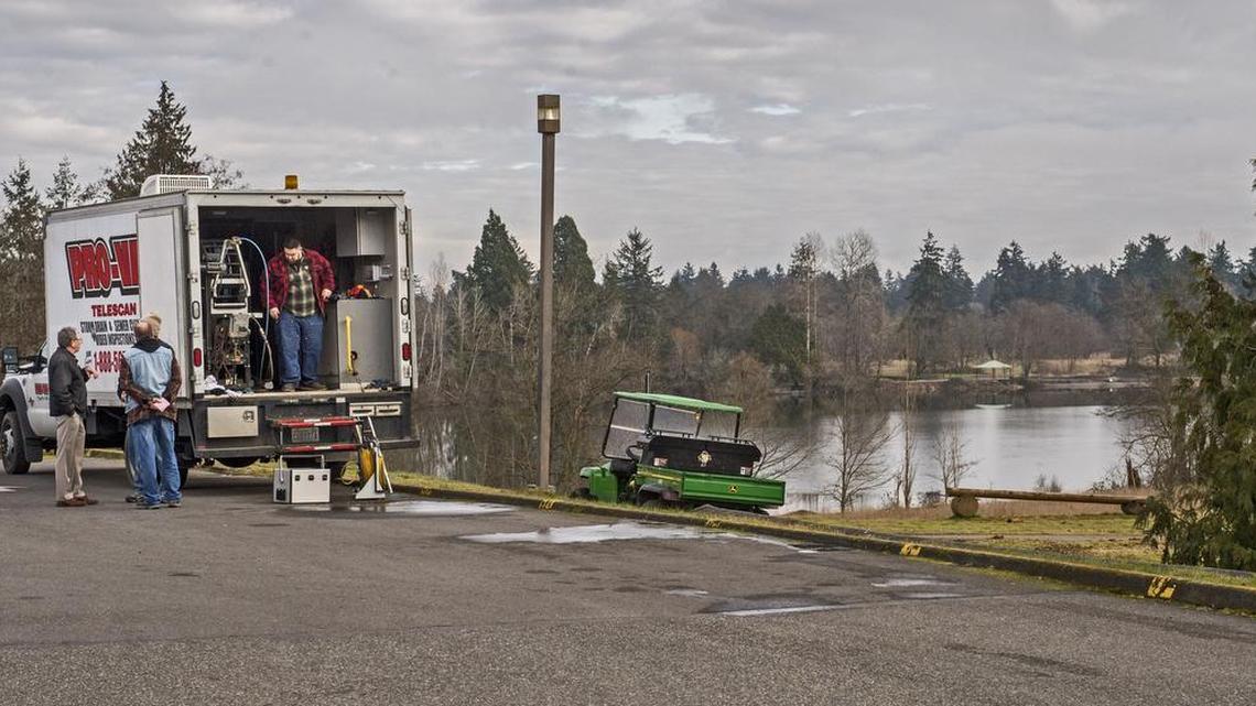 A crew packs up Tuesday after using special equipment to inspect sewer lines behind Pierce College in Lakewood. Sewage in Waughop Lake, right, at Fort Steilacoom Park might be coming from the lines.
