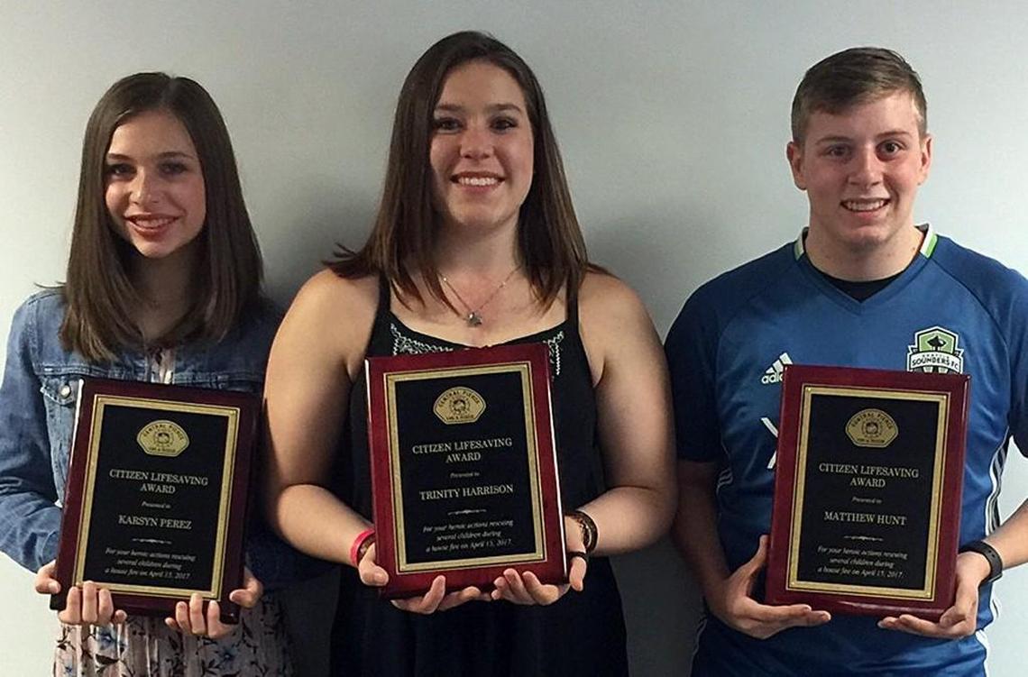 Karsyn Perez, from left, Trinity Harrison and Matthew Wood hold the Citizen Lifesaving Awards they were presented with Monday evening by Central Pierce Fire and Rescue.