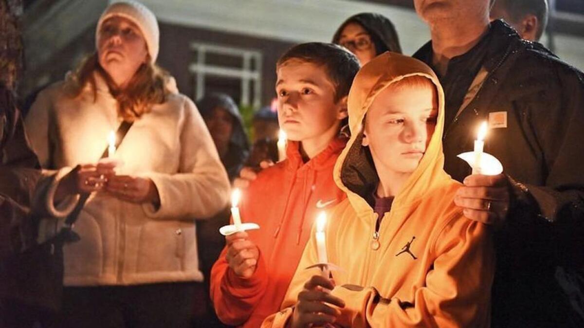 The aunt, uncle and cousins of the three children killed in Friday’s early morning house fire in Centralia hold candles Saturday night during a vigil at George Washington Park. From left are Sara Adams, in white, Corey Adams, 14, in orange, Justin Adams, 12, in yellow, and behind him Daryl Adams. The family is from Olympia.