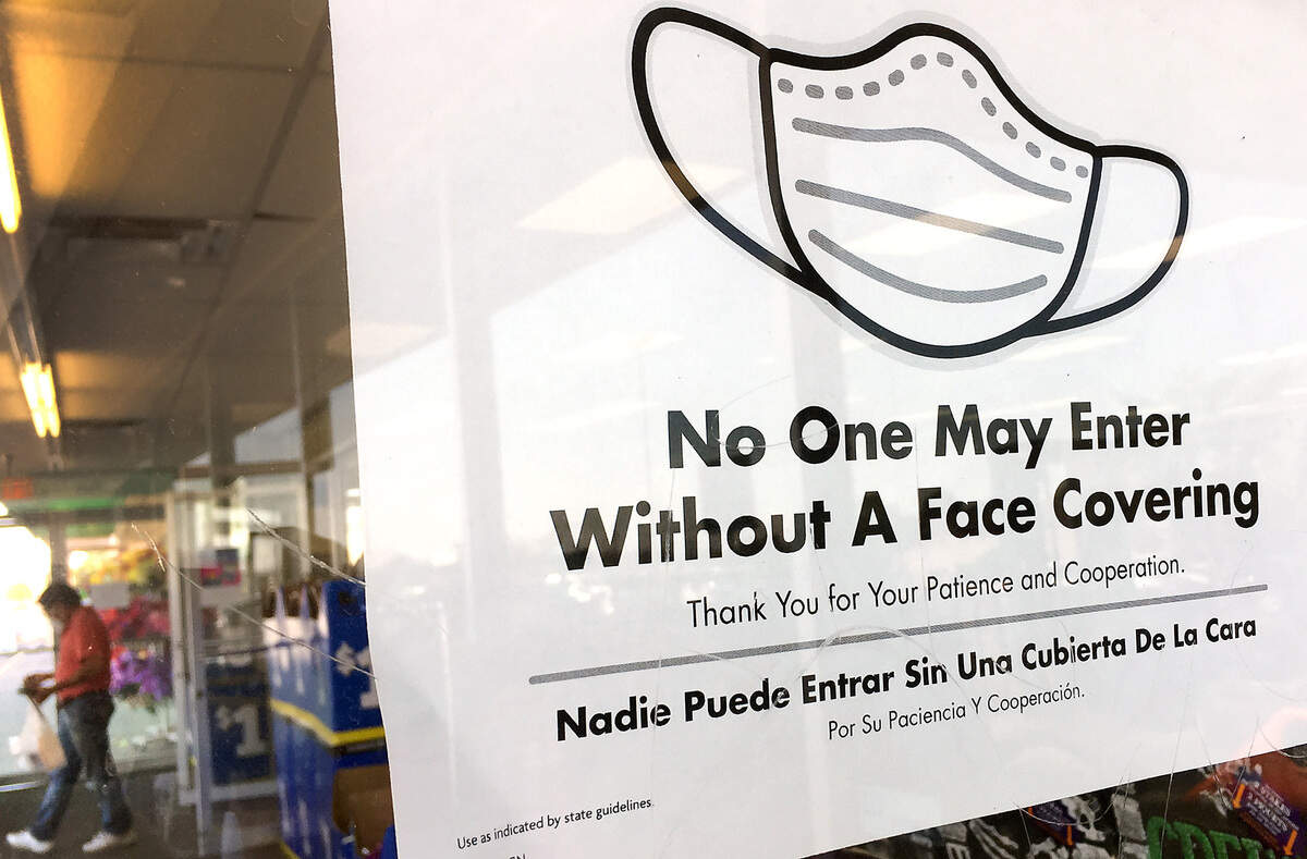 A bilingual sign posted at the entryway of a west Kennewick retail store prompts customers to follow the mask requirement during ongoing coronavirus pandemic.