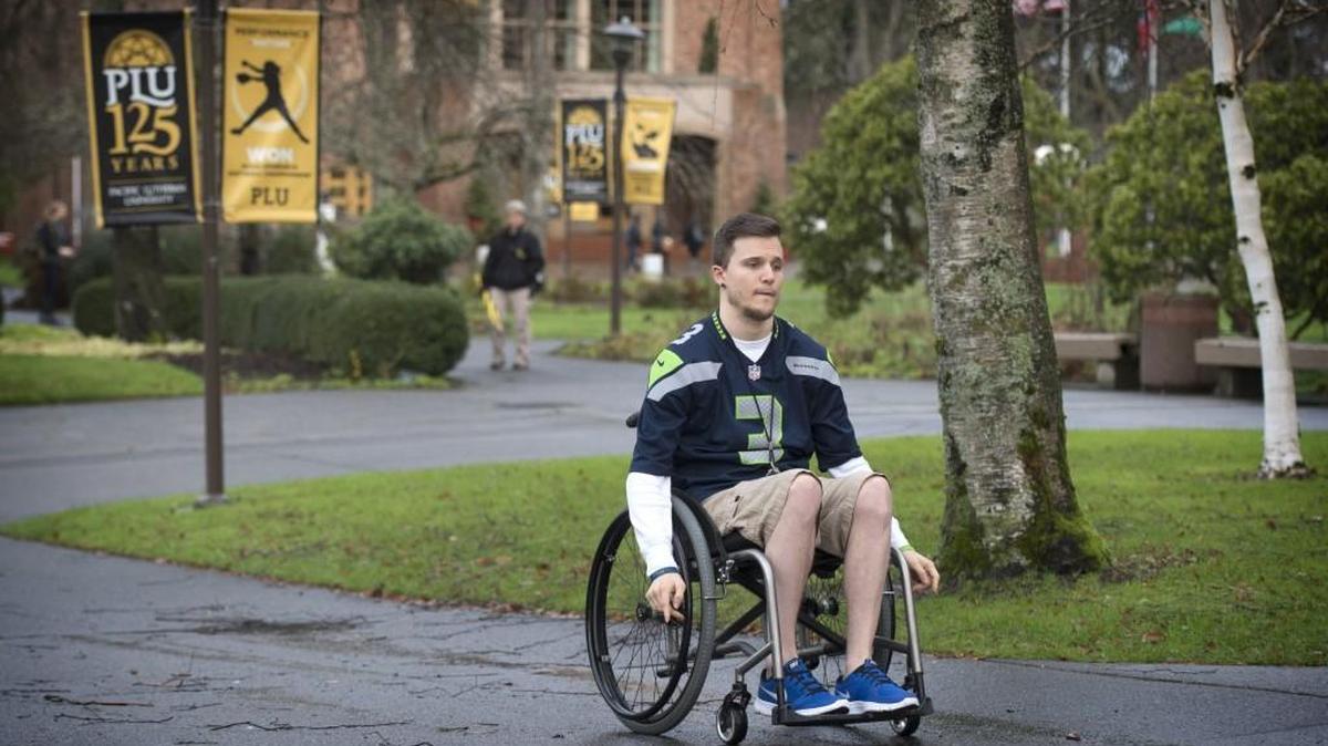 Logan Seelye wheels himself across the Pacific Lutheran University campus Dec. 11. Seelye suffered a spinal injury in a football accident in 2003 that left him paralyzed. Since then, he’s worked toward his goal to walk again, keeping in mind the quote that “life is 10 percent what happens and 90 percent how you react to it.” He’s written a book inspired by that mentality that comes out this week.