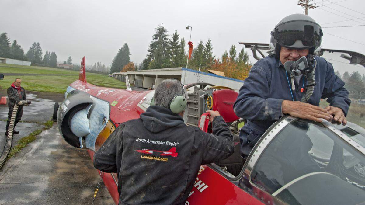 Owner/pilot Ed Shadle stands in the cockpit of North American Eagle, a jet car, during a cleaning operation October 19, 2013, after a recent test run on a dry lake bed in eastern Oregon. The vehicle is a fighter jet that has been converted to a car intended to break the land speed record.