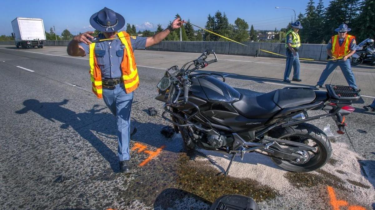 Washjngton State Patrol officers work the scene where a motorcyclist was killed Thursday afternoon when he collided with a box truck (in background) eastbound on state Route 16 in Tacoma.