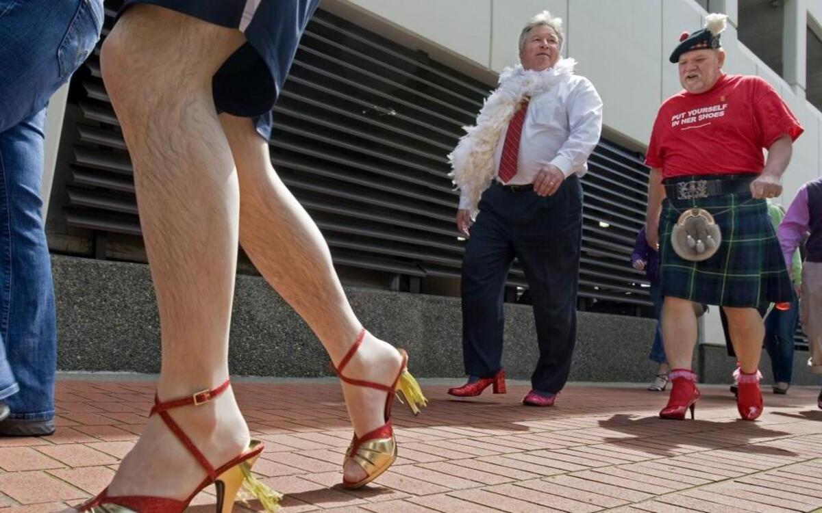 Bob Wiede, right, and deputy prosecutor Phil Sorenson, center, join a couple of hundred men and women walking a mile along Pacific Avenue in downtown Tacoma during the 2011 Walk a Mile in Her Shoes event.