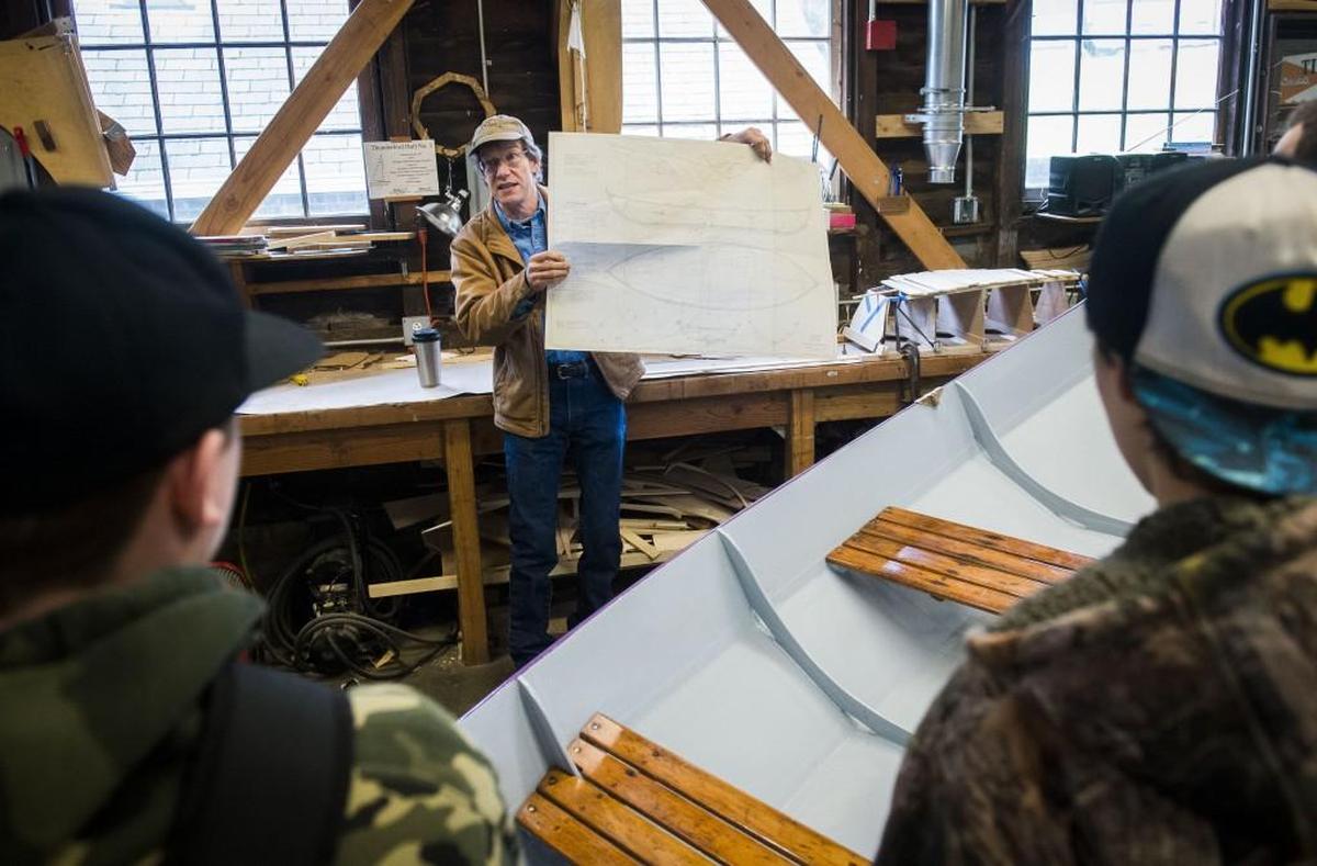Tom Regan shows plans for an upcoming boat building to Henderson Bay High School students during a presentation at the Eddon BoatShop in Gig HarborJan. 18. The BoatShop will offer a mentorship program to selected students at the high school where they will learn how to build a boat from scratch.