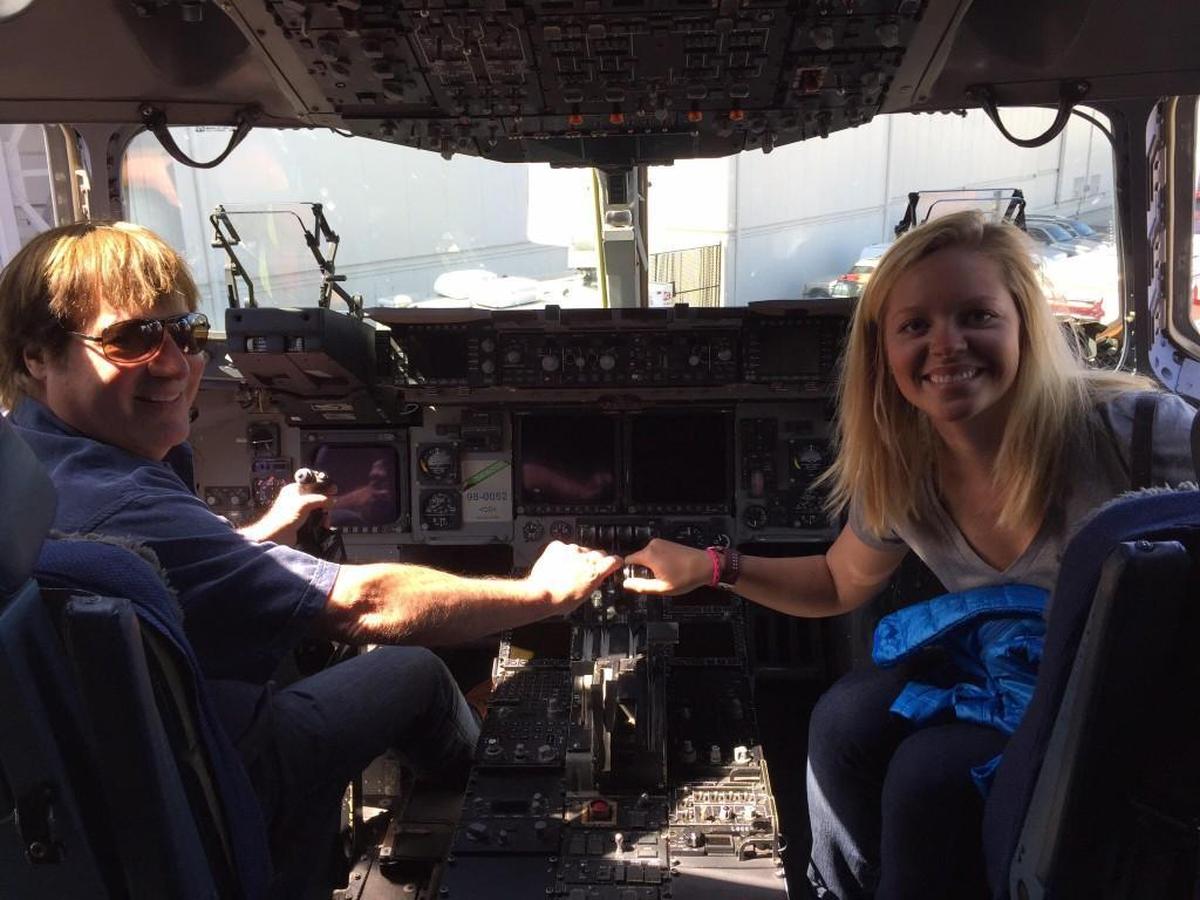 Jeff Lang sits in a military plane with a Miss Washington USA contestant at Bremerton military base.