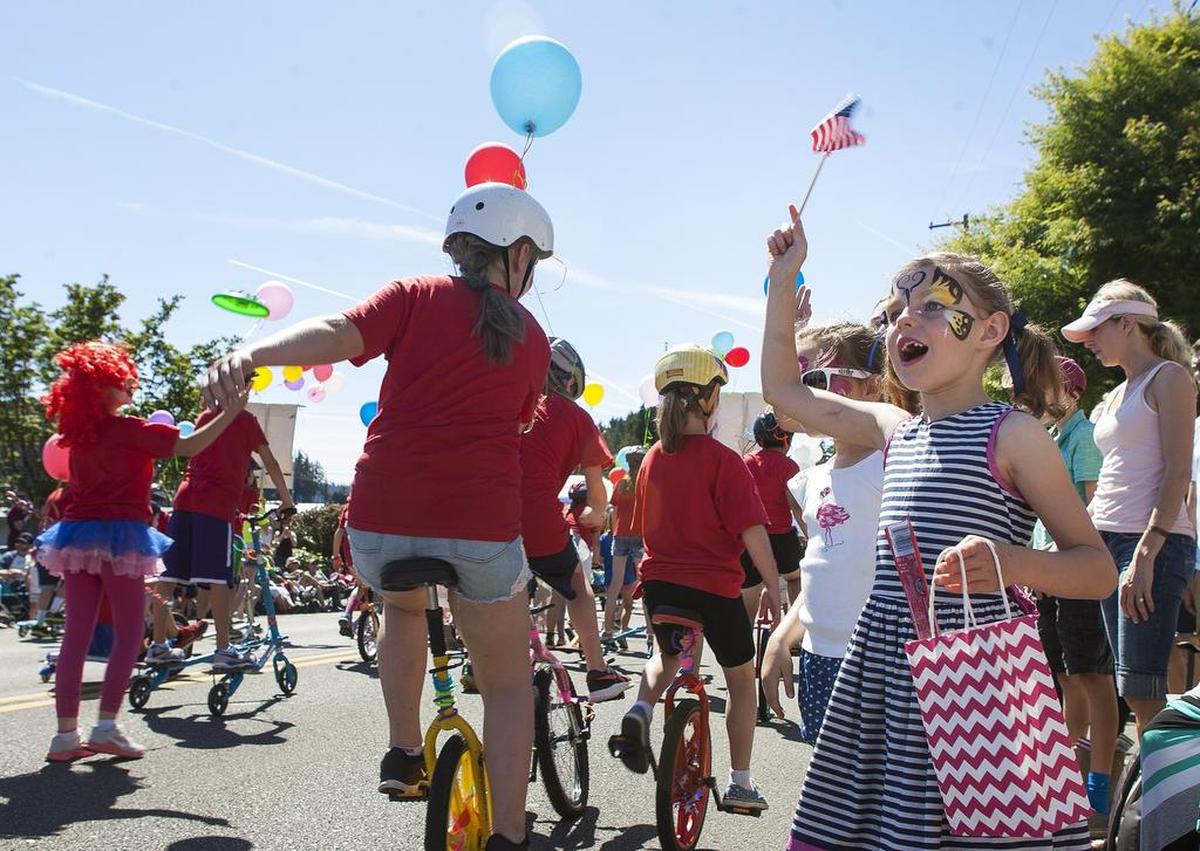 Ella Fowler, 7, right, cheers as unicycles pass by during the Yo’ Ho’ Harbor Grande Parade at the Maritime Gig Festival in Gig Harbor, Wash., on Saturday, June 4, 2016.