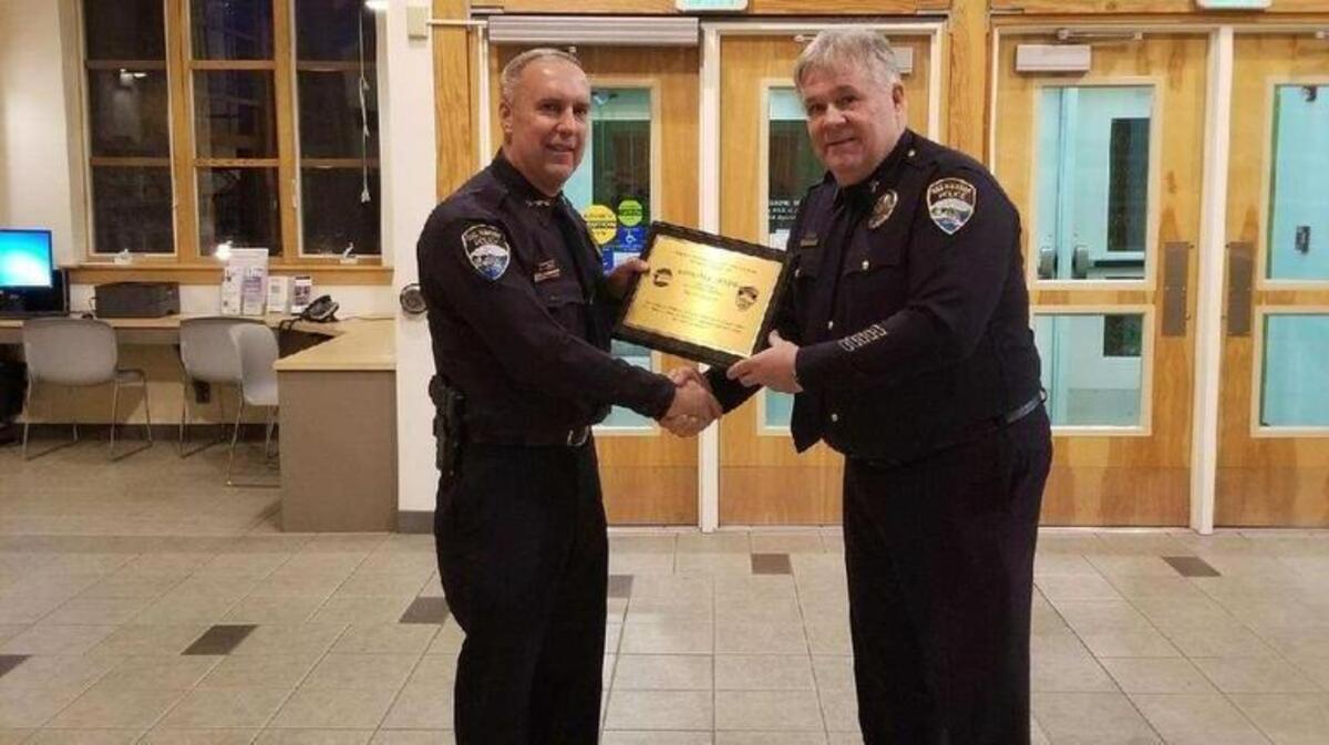 Gig Harbor Police Chief Kelly Busey shakes hands and presents a plaque to Roger Roth, who was the Gig Harbor police chaplain for 17 years.
