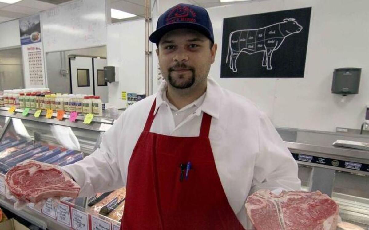 
Ricardo “Benny” Topete, manager of the newly opened Harbor Farms Meat and Seafood, shows a porterhouse and a rib-eye steak Monday morning at the Kimball Drive store in Gig Harbor.
