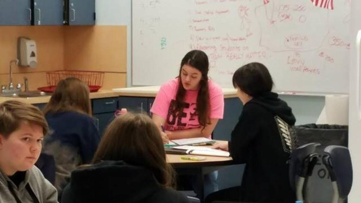 Stacie Finley, wearing a pink shirt, works with a group of students on lesson plans. She is a part of Gig Harbor and Peninsula high schools’ Teacher Academy.