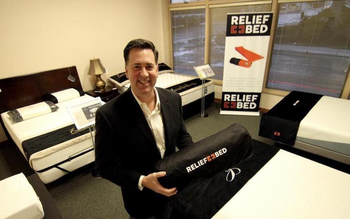 Relief Bed founder and Gig Harbor native Scott Smalling shows some of his product line Monday morning at the Northwest Furniture Bank in downtown Tacoma.
