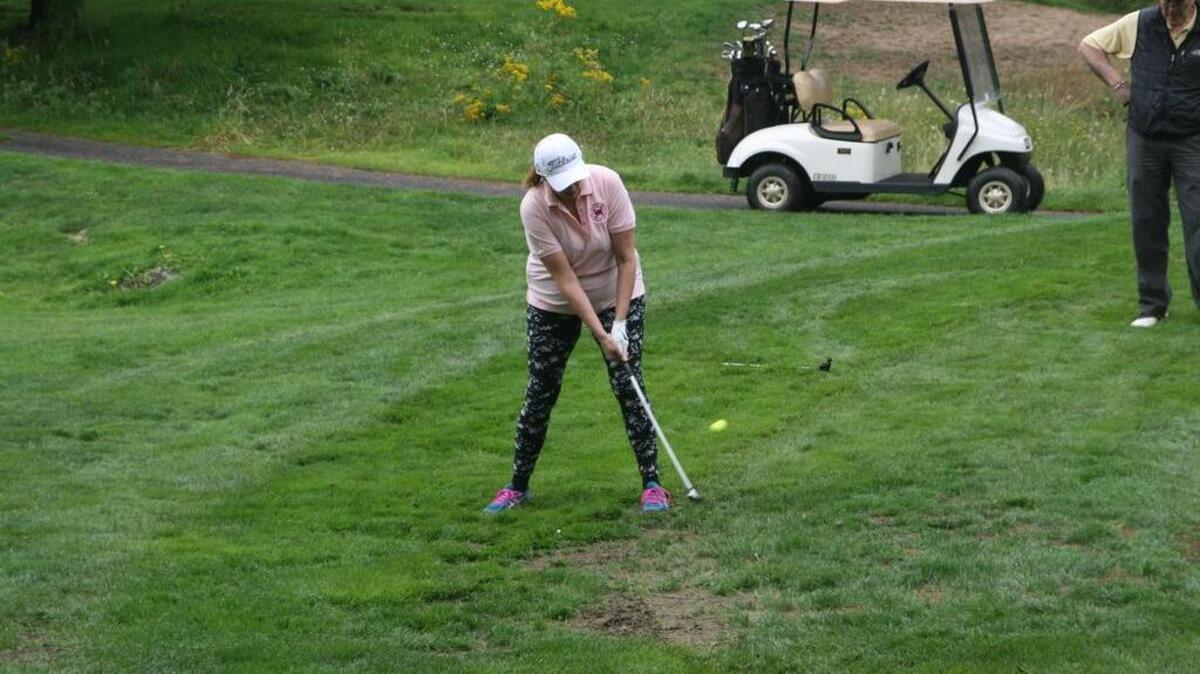 Commissioner Sheila Niven of the Key Peninsula Fire Department’s team chips one on the green Friday at the annual Neighbors Helping Neighbors Scramble Golf Tournament to equally benefit the Hope Recovery Center and the Red Barn Youth Center.