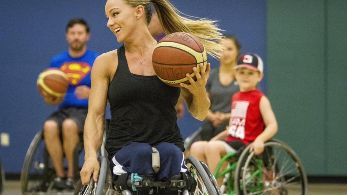 Megan Blunk, center, talks about how to dribble the ball during a demonstration of wheelchair basketball at Harbor Ridge Middle School on Friday.