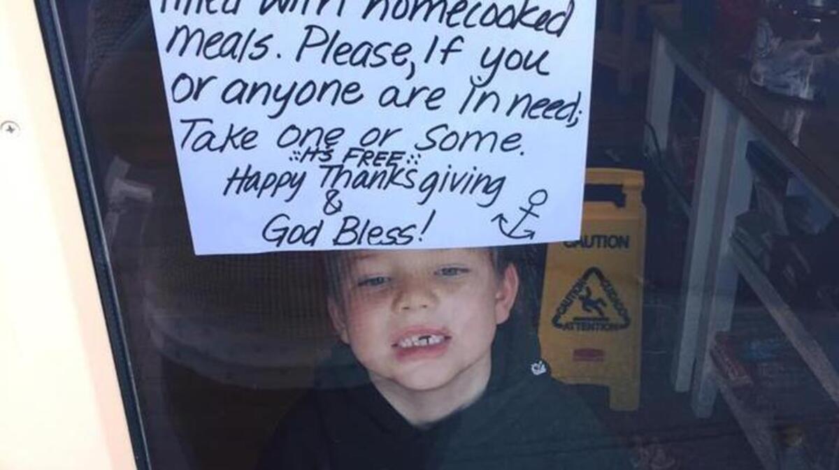 Two of owner Stephanie Sagle’s children pose by the sign announcing the store’s free Thanksgiving dinners.
