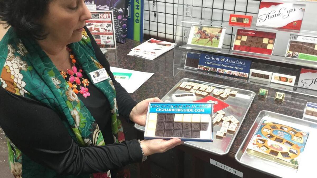 DPI Print owner Pat Schmidt shows off a personalized Belgian chocolate package her Gig Harbor-based company recently made for the City of Gig Harbor.