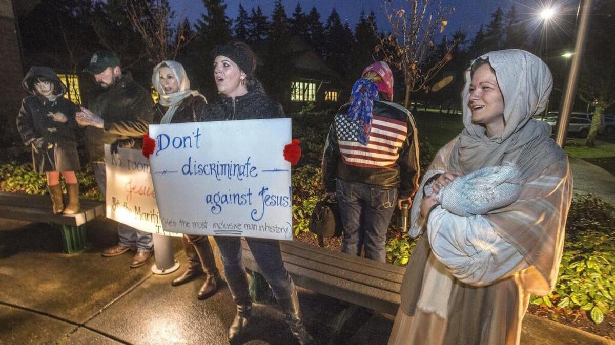 Hannah Lazicki, a mother of four from Gig Harbor dressed up as the Virgin Mary and held a swaddled baby Jesus in the rain as she and other protestors, who want the city to allow a Christmas nativity scene at Donkey Creek Park, sang Christmas carols in front of the Gig Harbor Civic Center Dec. 12.