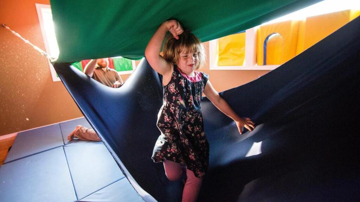 Annie Pagni, 6, plays in a Southpaw acrobat lycra swing in a sensory room designed by Alexander Lopiccolo in Gig Harbor.
