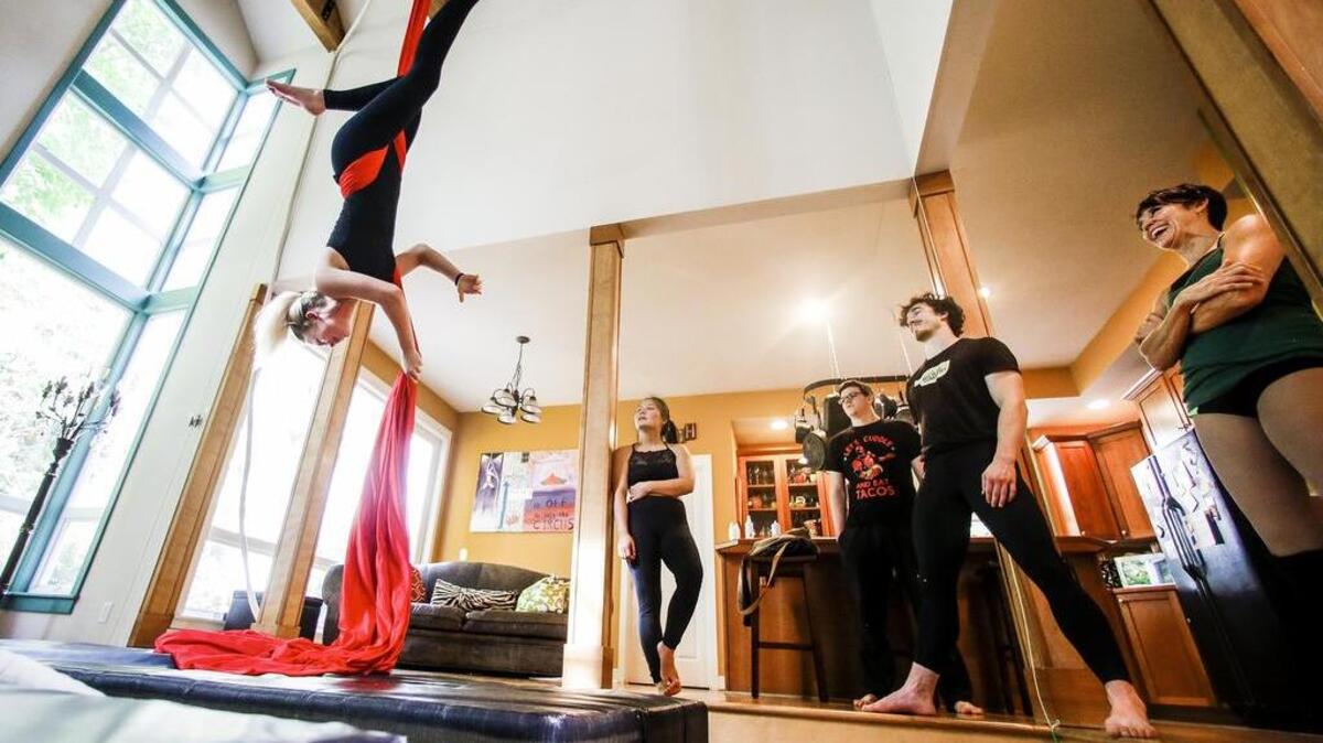 Kate Johnson, left, practices a drop using aerial silks while the class and instructor Pamella Inveen, right, look on during an Aerial Fitness class.