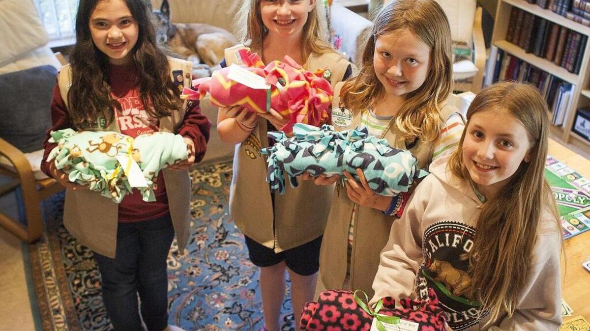 Girl Scouts Rylie Kalahiki, Abby Matthews, Moriko Peterson and Olivia Thoennes, from left, hold up blankets similar to the ones they recently handed out to patients at St. Anthony Hospital in Gig Harbor.