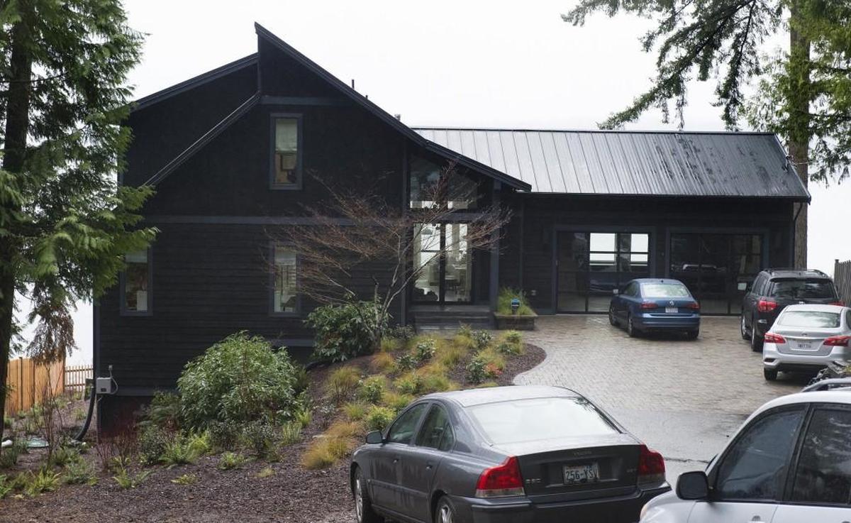The exterior of the home is black with slated gray accents and a large finished garage with a see-through door.
