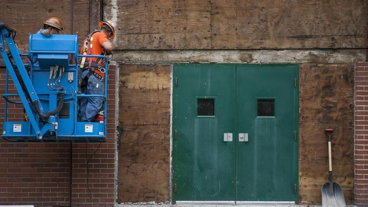 Crews from Washington Patriot Construction work on the brick facade outside of the pool building at Peninsula High School in Purdy last year. The Peninsula School District is preparing to ask voters to approve a capital measure that will secure funds for much needed repairs on facilities throughout the district.