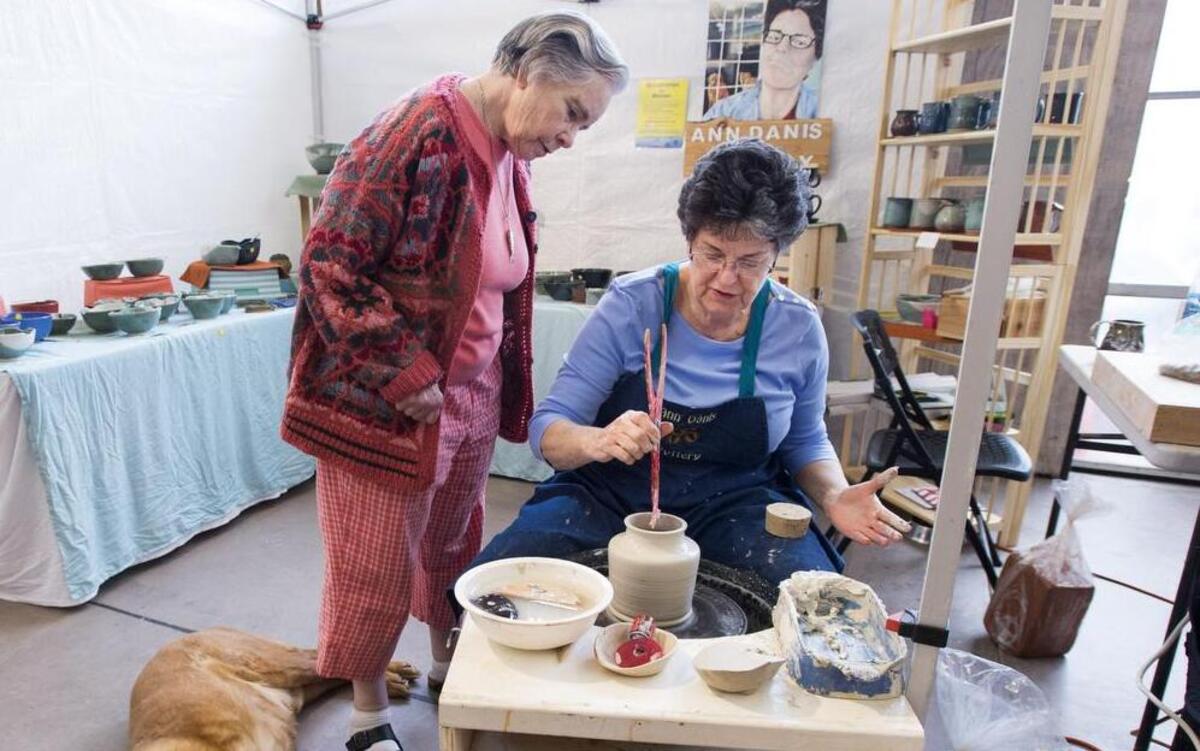 Carol Robinson, left, helped Ann Danis at the Gig Harbor Farmer’s Market and was instrumental in her receiving a $5,000 scholarship from the Minerva Fund to pursue a degree in fine arts. Minerva is a nonprofit dedicated to helping older women return to school. At left is Danis’ one-eyed dog, Templeton.