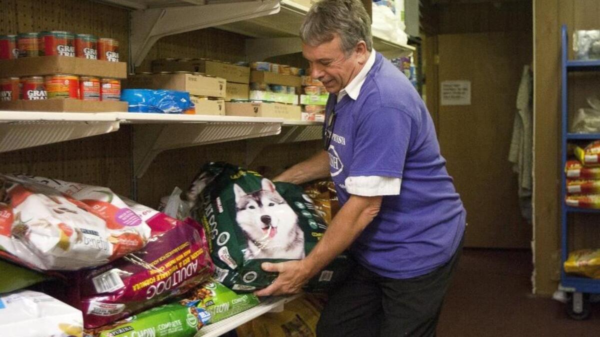 Volunteer Kevin Jacobsen shows off a bag of donated dog food during a tour of the FISH food bank. The food bank celebrated its 40th birthday Tuesday.