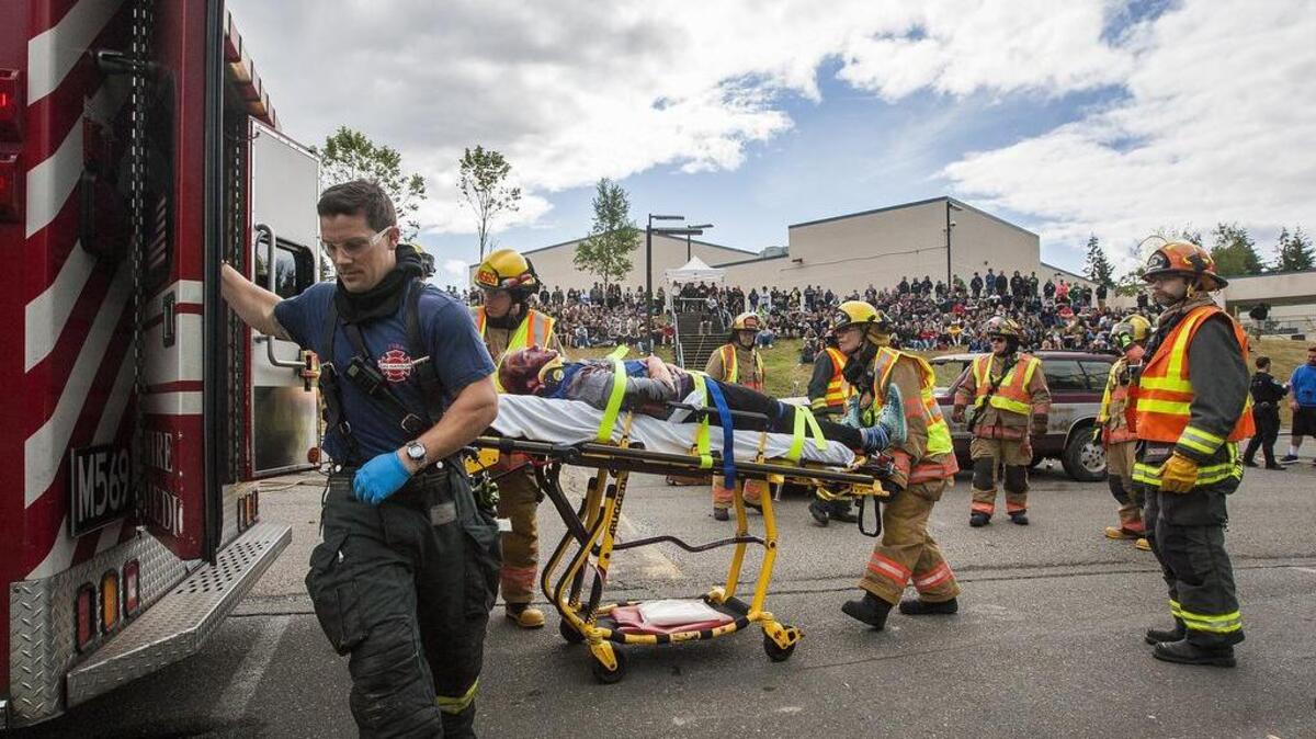 Gig Harbor Fire & Medic crews load students into ambulances while responding to a simulated car accident at Gig Harbor High on Friday.