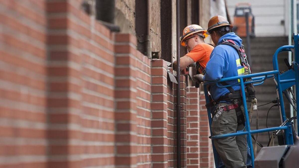 Crews from Washington Patriot Construction work on the brick facade outside of the pool building at Peninsula High School in Purdy.