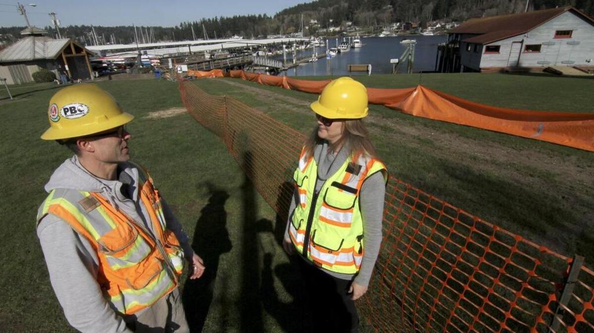 City of Gig Harbor construction supervisor George Flanigan and senior engineer Emily Appleton discuss the utility installation construction project at Jerisich Dock last week. Other improvements underway include resurfacing of the gangway and a project to improve Lift Station 4.
