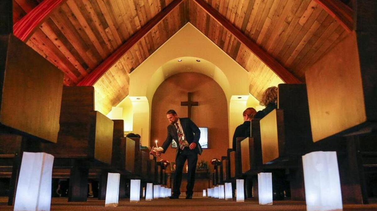 Ron Winter lights candles inside the chapel during the Luminary Remembrance Walk at Haven of Rest in Gig Harbor on Saturday.