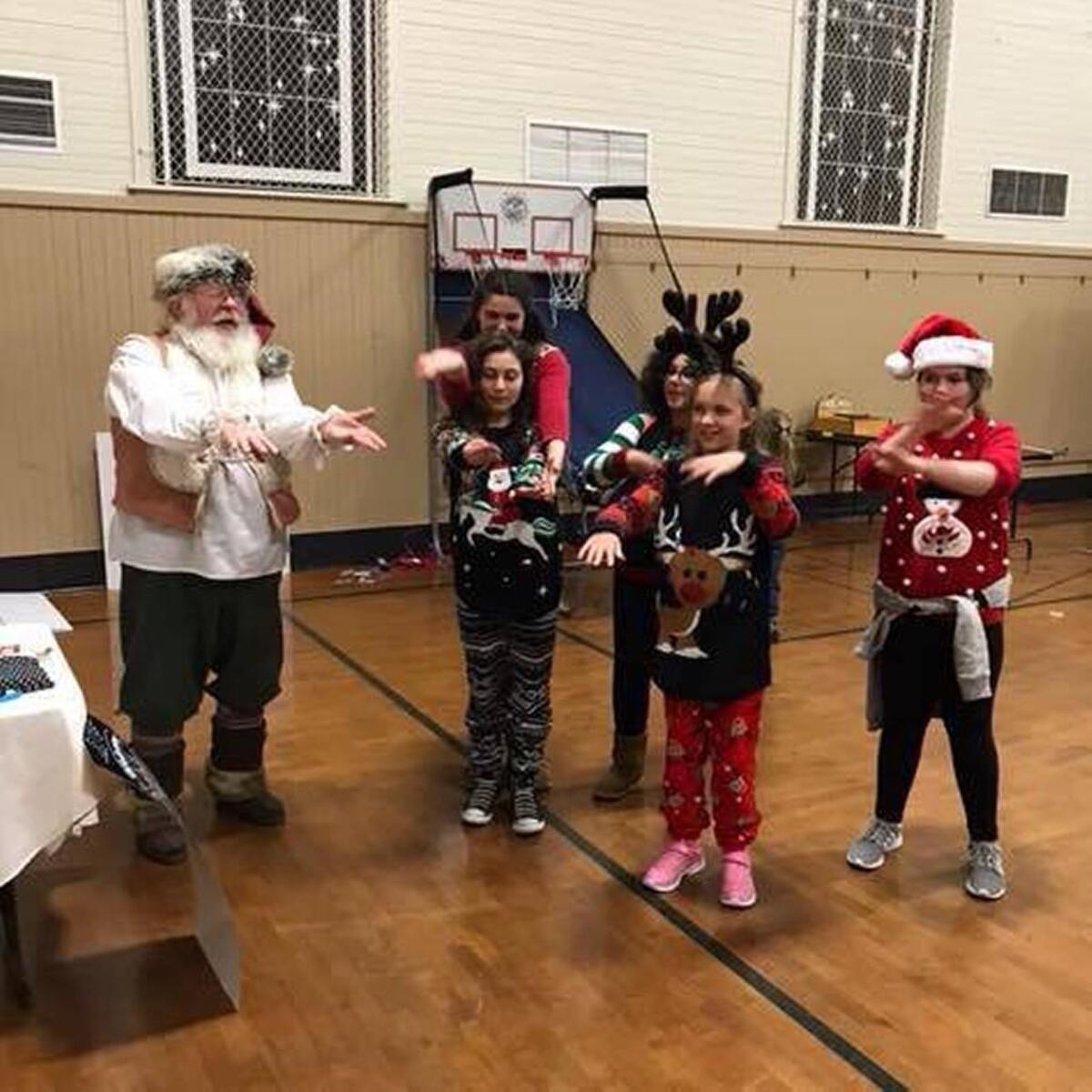 Girl Scouts from the Key Peninsula do the Hokey Pokey with Santa during the KP Christmas Party on Monday night.