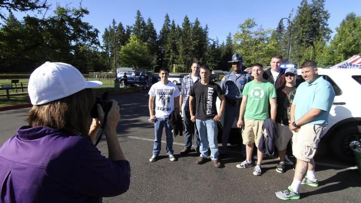 
Carlene Joseph takes a photo of Joint Base Lewis-McChord soldiers with Washington State Patrol trooper and recruiter Grant Campbell. 
