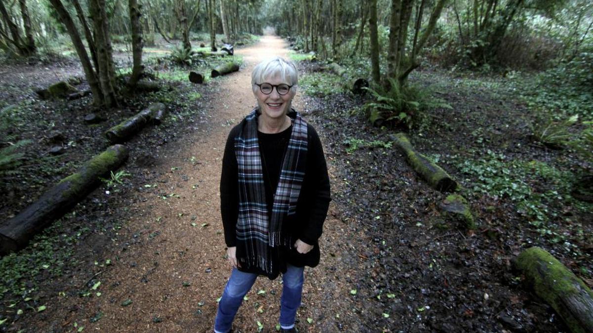Dawn Ancich-Stanton, a local artist, longtime Gig Harbor resident and former Historical Preservation and Special Projects representative for the City of Gig Harbor, is framed by the holly grove at the Wilkinson Family Farm Park on Monday afternoon.