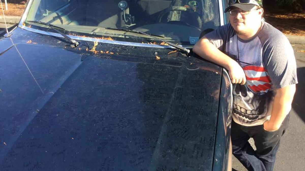 Peninsula High junior Austin Lyon stands next to his 1996 Ford F-250 pickup truck. The truck’s hood has messages from PHS students written to fellow students Kyle Stillion and James Oatridge, who died days apart earlier this month.