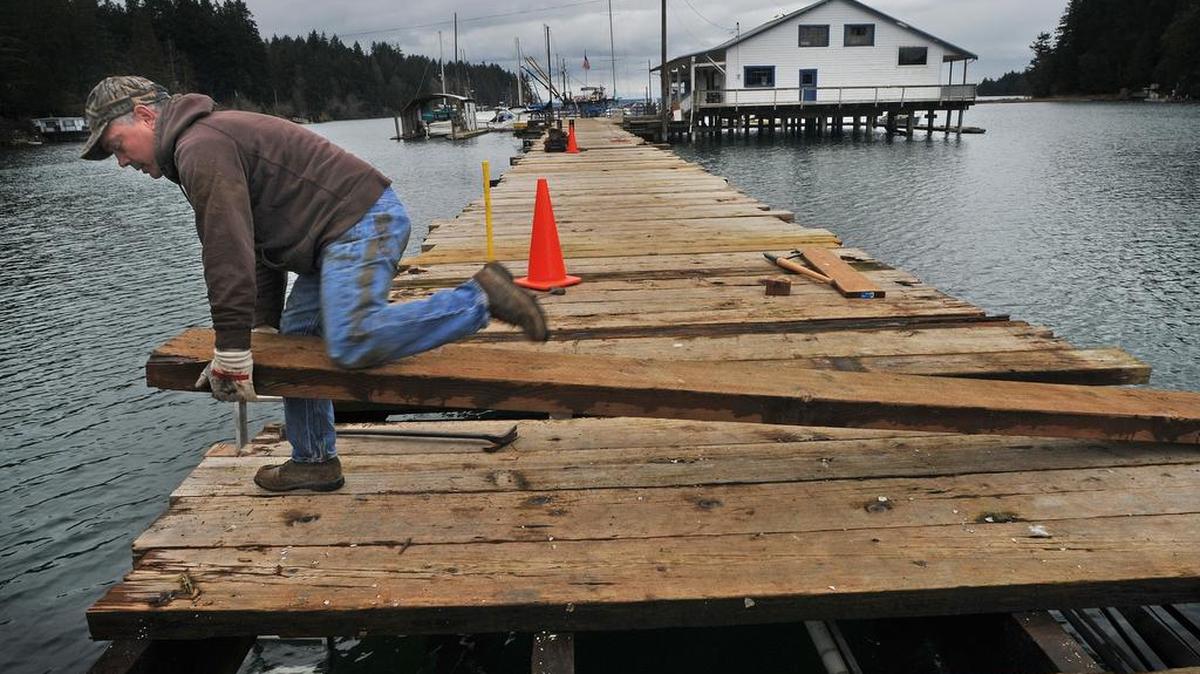 The Lakebay Marina is not reopening next season, according to owner Mark Scott. Scott bought the marina — which includes a cafe, boat slips and a fueling station — in 2013. Leonard Spadoni, 49, of Gig Harbor, a childhood friend of Scott’s and a contractor, wrestles a plank into place on Feb. 6, 2013. Scott said his inability to post advertising and the lack of business is contributing to the decision.