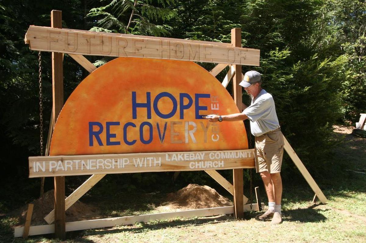 Artist Jeff Johnson adds color to the Hope Recovery Center sign at its future building site at the Lakebay Church Community Garden at the sign’s permanent location on the Key Peninsula Highway.