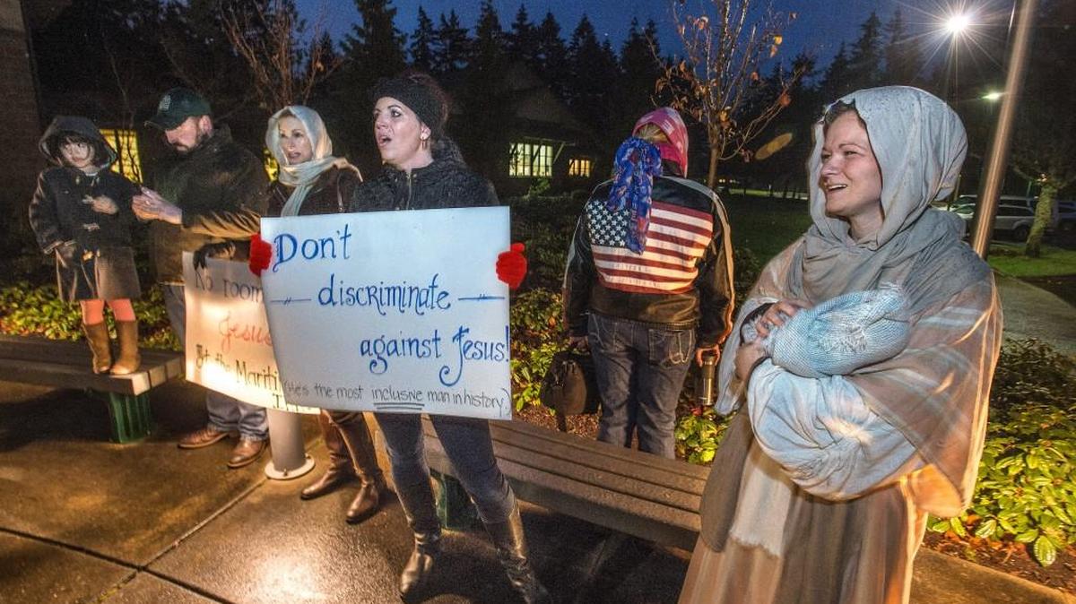 Hannah Lazicki, a mother of four from Gig Harbor dressed up as the Virgin Mary and held a swaddled baby Jesus in the rain as she and other protestors, who want the city to allow a Christmas nativity scene at Donkey Creek Park, sang Christmas carols in front of the Gig Harbor Civic Center on Monday.