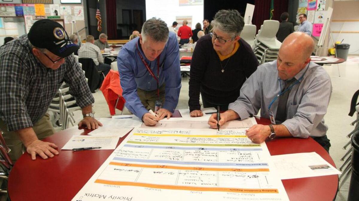 From left, Key Peninsula resident Curt Scott, Peninsula School District Superintendent Rob Manahan, Patricia Scott, Curt’s wife, and Assistant Superintendent Dan Gregory compile the findings of their team, one of many teams, at last week’s Facilities Evaluation session at Goodman Middle School.