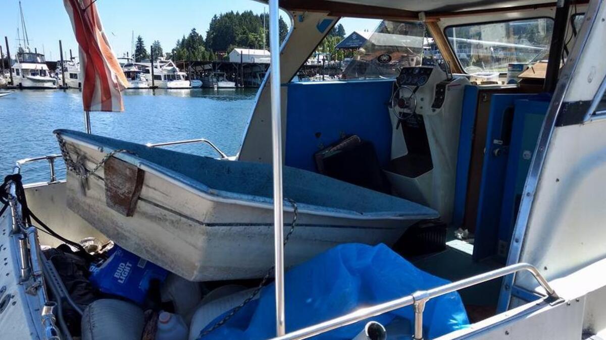 The city of Gig Harbor has scheduled the auction of a derelict vessel abandoned at Jerisich Dock since last November or December. Decorated with a string of tattered nautical flags, the vessel, a 1968 Uniflite 31, features a passenger bay filled with garbage and a dinghy loaded into the boat by Gig Harbor Police after it became filled with rainwater and threatened to sink.