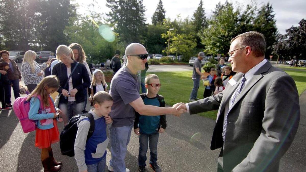 Parent Hessam Wessal greets Discovery Elementary Principal David Brooks as he drops his children off at school in September 2014. Discovery is one school on the list that would receive money from the district for system and efficiency upgrades should voters approve the proposed $220 million bond in April.