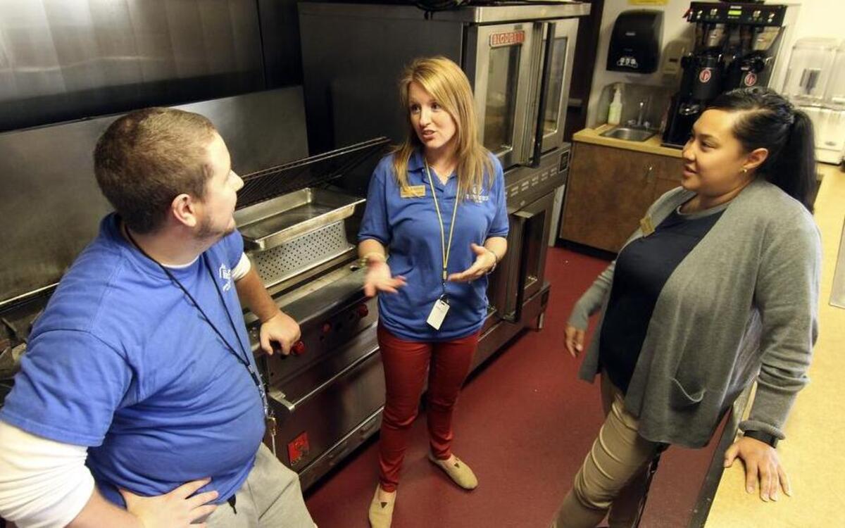 
Lakewood Boys and Girls Club program coordinator Jeff Shearer, left, program director Mallory Carmichael, center, and branch director Katey Sias visit at the Gig Harbor Boys and Girls Club kitchen after a 10-year mortgage on the facility’s kitchen was paid off by the Altrusa Club.
