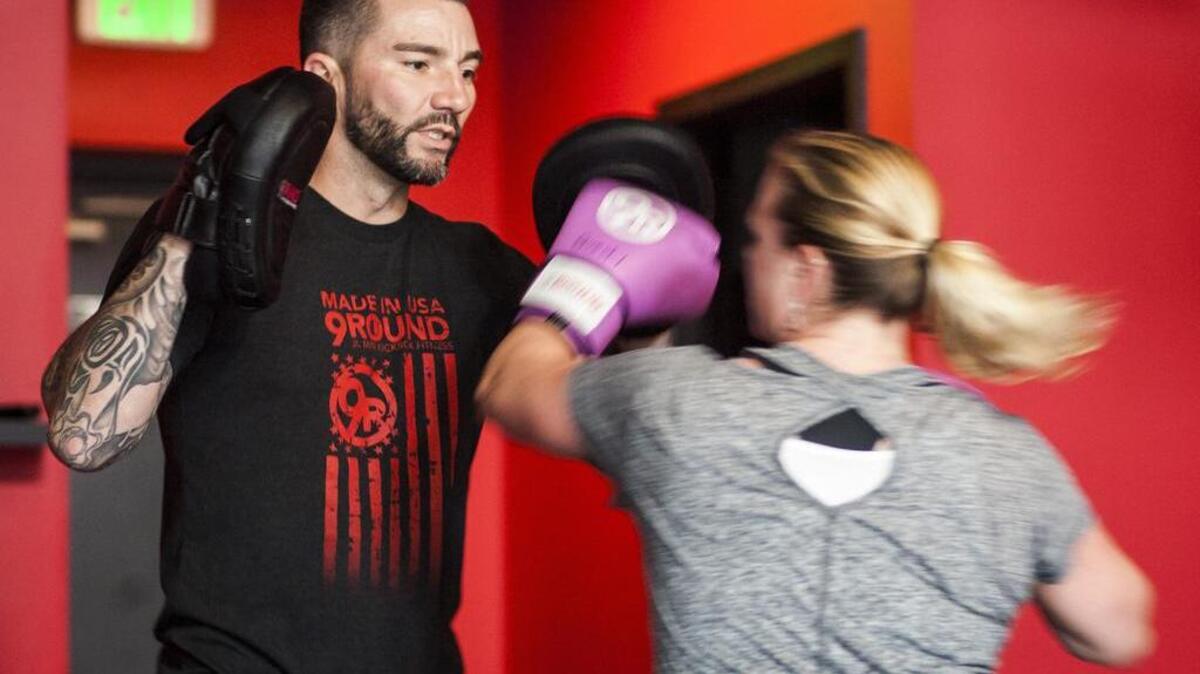 Tim Olson, owner of 9Round, spars with Nicole Hemphill at the kickbox gym in Gig Harbor on Friday. The 9Round workout consists of nine stations divided throughout the 30-minute time frame.