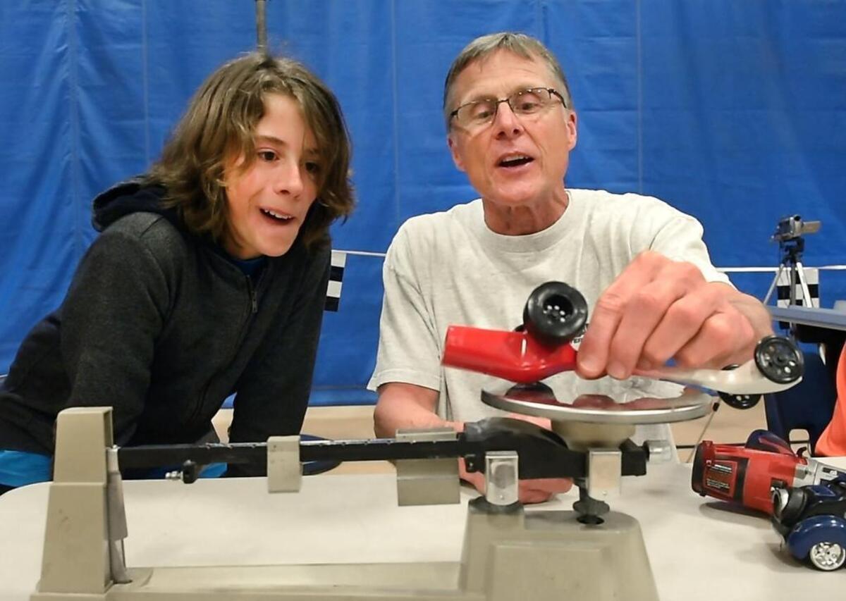 Braden Anderson, 13, works with teacher Kelly Bolender to make his sure his carbon dioxide-powered race car was within the weight allowance to compete in a derby.