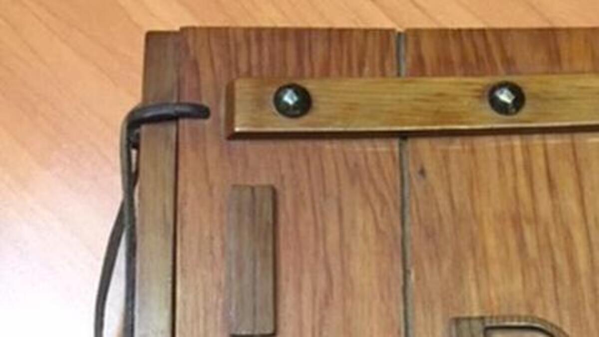 A book with a unique wood cover, rivets and a leather cord commemorating the opening of the Tacoma Narrows Bridge in 1950 was recently returned to Gig Harbor after it was discovered at a Goodwill in Nevada.