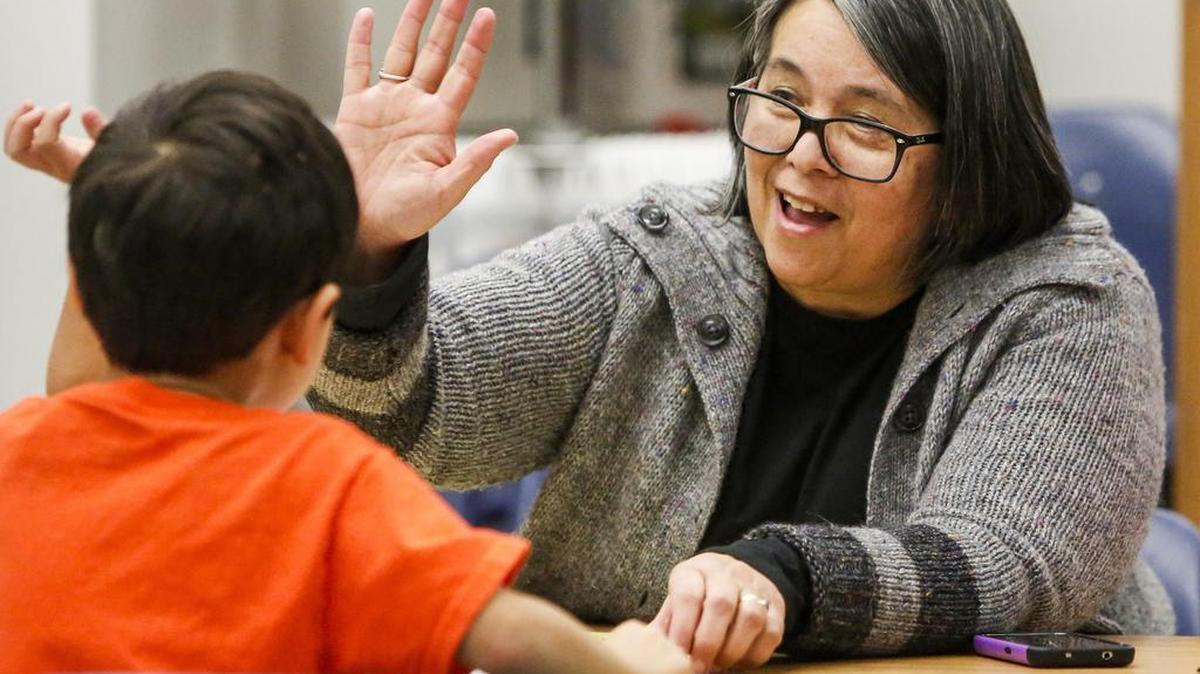 Jacque Crisman, principal at Artondale Elementary School, gives a student a high-five after he completed an exam. Crisman was part of a group of Peninsula School District elementary principals who sought out training to help students who have encountered traumatic experiences.
