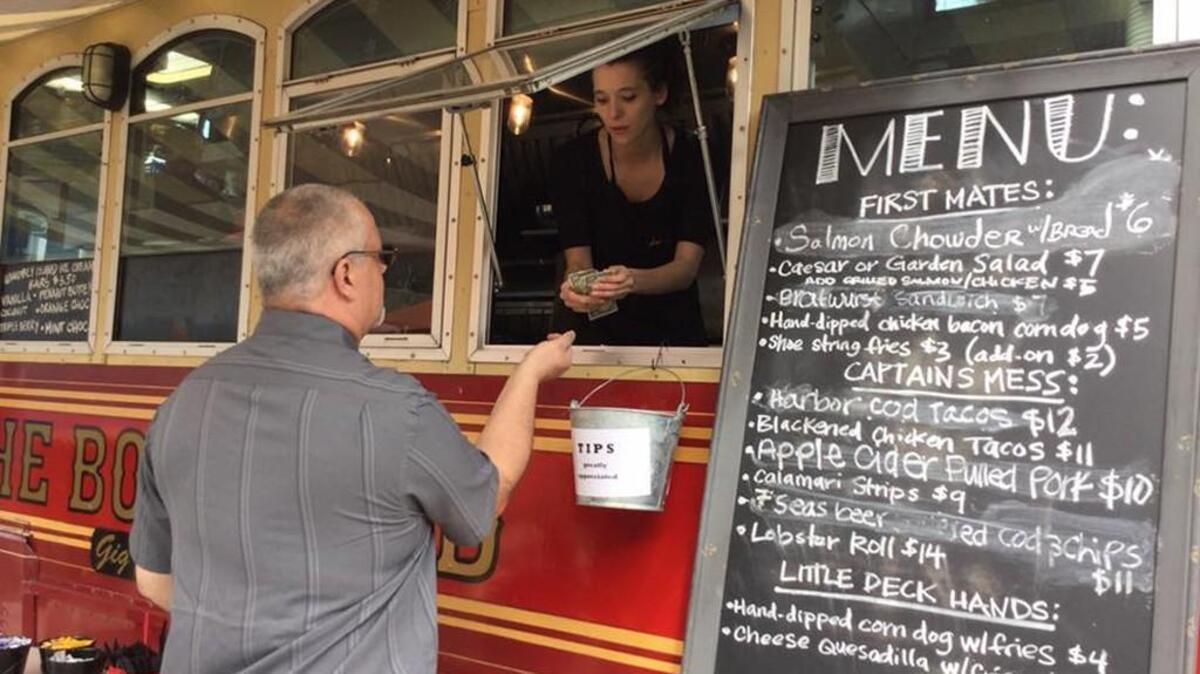 JW @ The Boatyard employee Oren Tovar takes a lunch order Tuesday afternoon at the trolley. The Trolley opened Friday and was quickly doing business to eager customers during the Gig Harbor Paddler’s Cup on Saturday and Sunday.