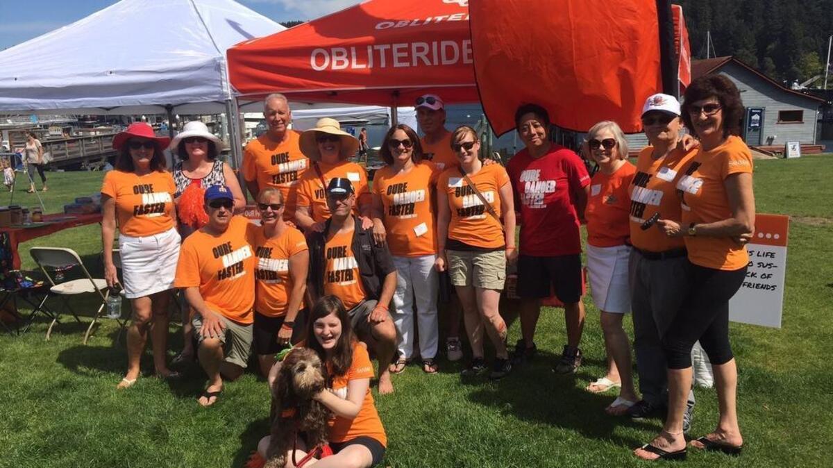 Gig Harbor resident Ellen Betit, fifth from left in the top row, served as team captain at the Gig Harbor Cares rest stop Saturday for Obliteride riders at Skansie Park when they stopped for some food, water and a bathroom break.