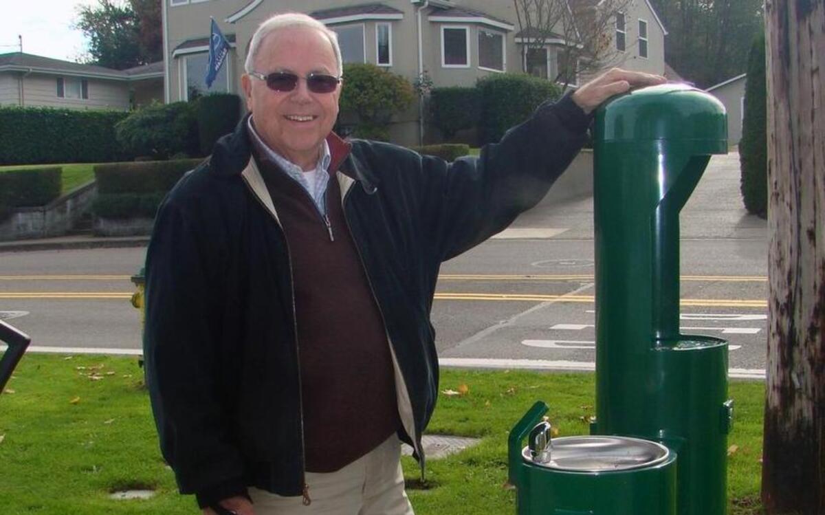 Dick Kuykendall and his dog, Coco, stand next to the new fountain at Eddon Boat Park.