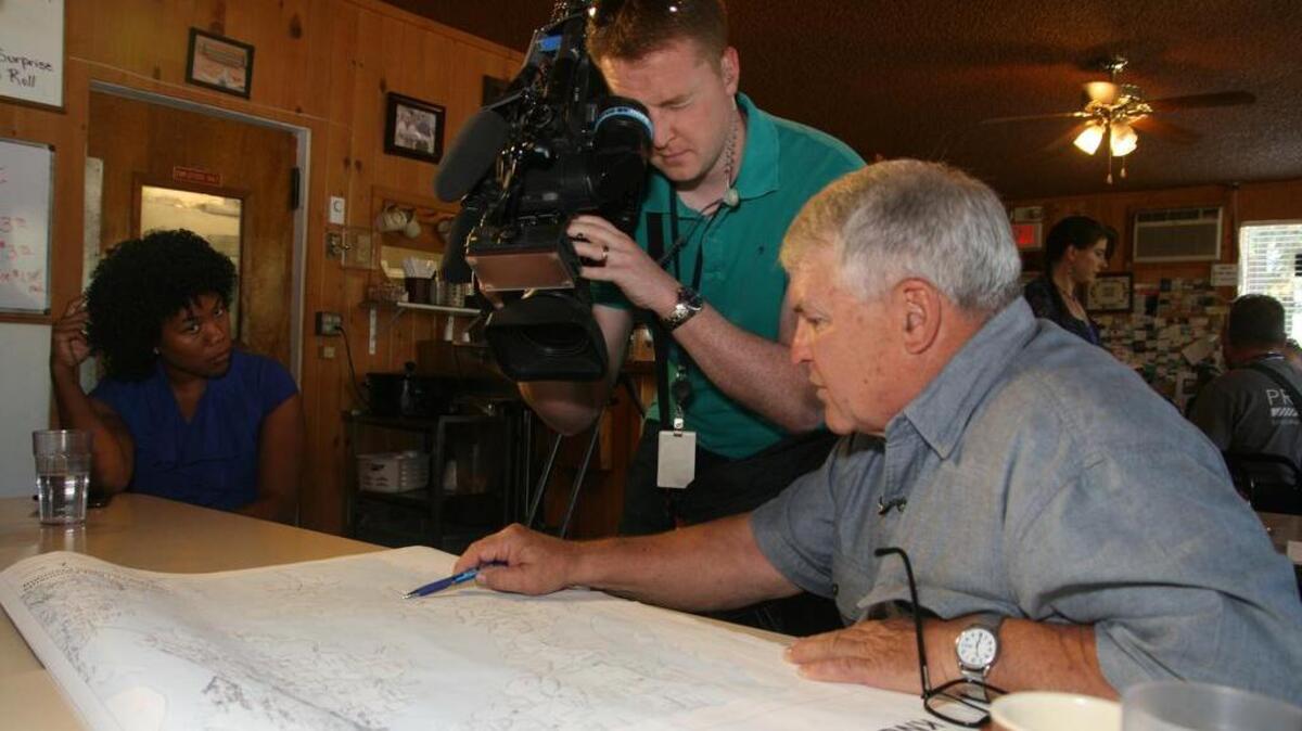 At the Home Port restaurant on the Key Peninsula, Peninsula Emergency Preparedness Coalition chair Curt Scott, right, shares with KING 5 TV reporter Jenna Hanchard and videographer Ryan Coe a discussion of what can be anticipated when our area is devastated by a major earthquake.